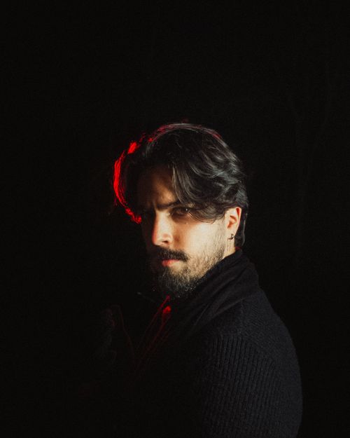Moody portrait of a bearded man in red accent lighting — Allan Carvalho on Pexels