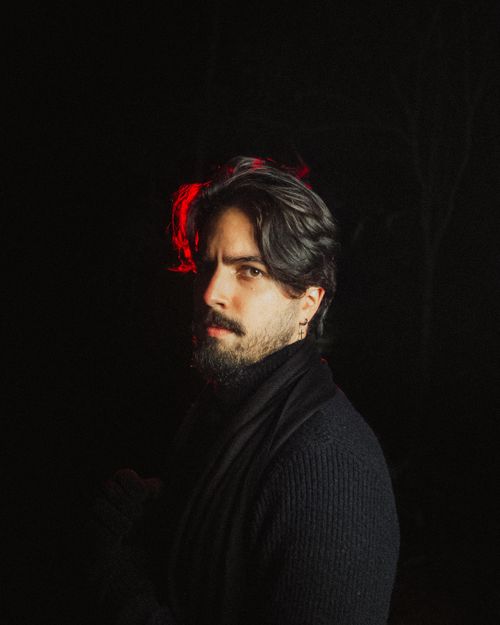 Free A man poses with a moody expression under dramatic lighting. Stock Photo