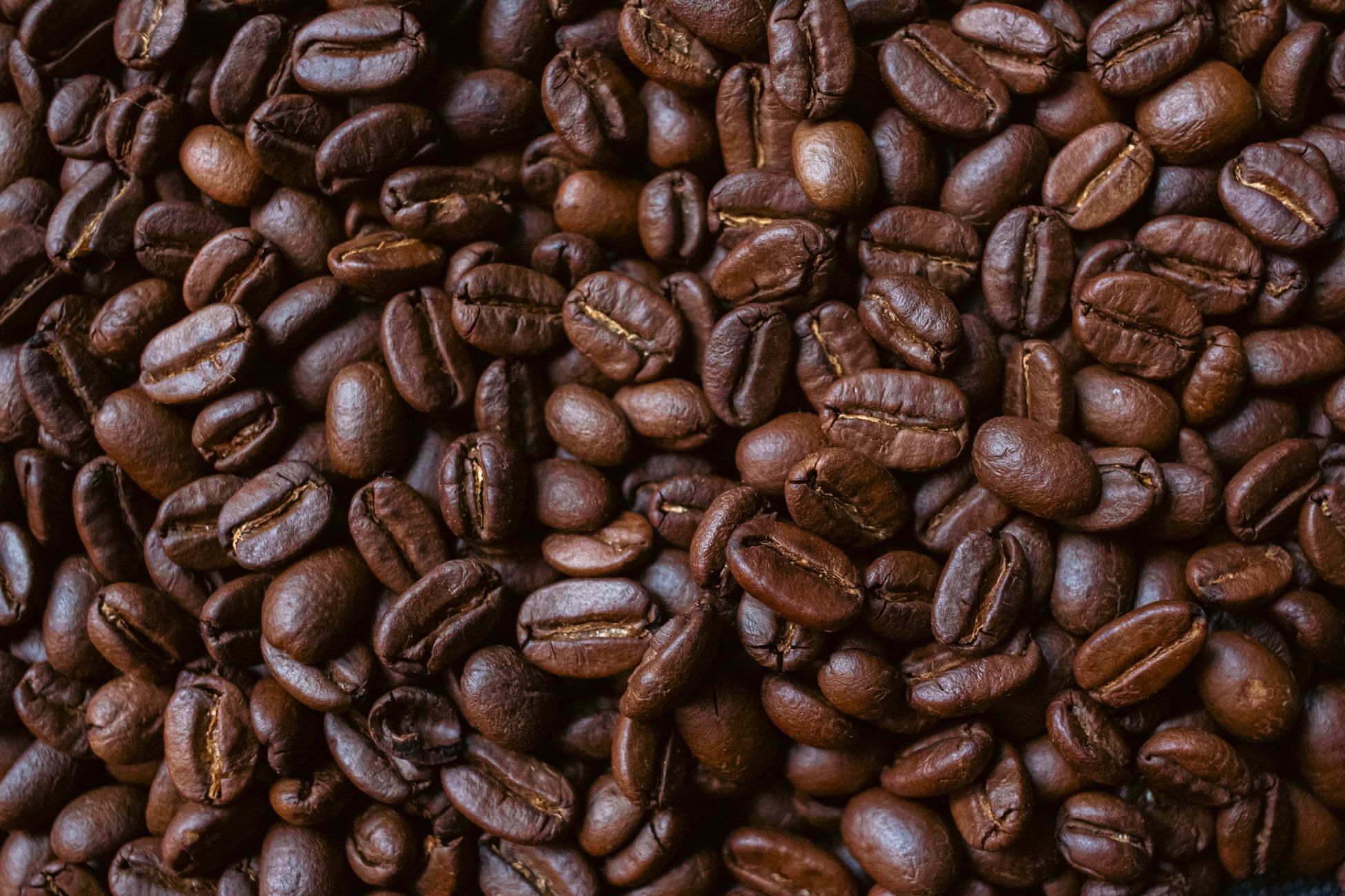 Closeup of aromatic roasted coffee beans showcasing rich textures and deep brown hues.