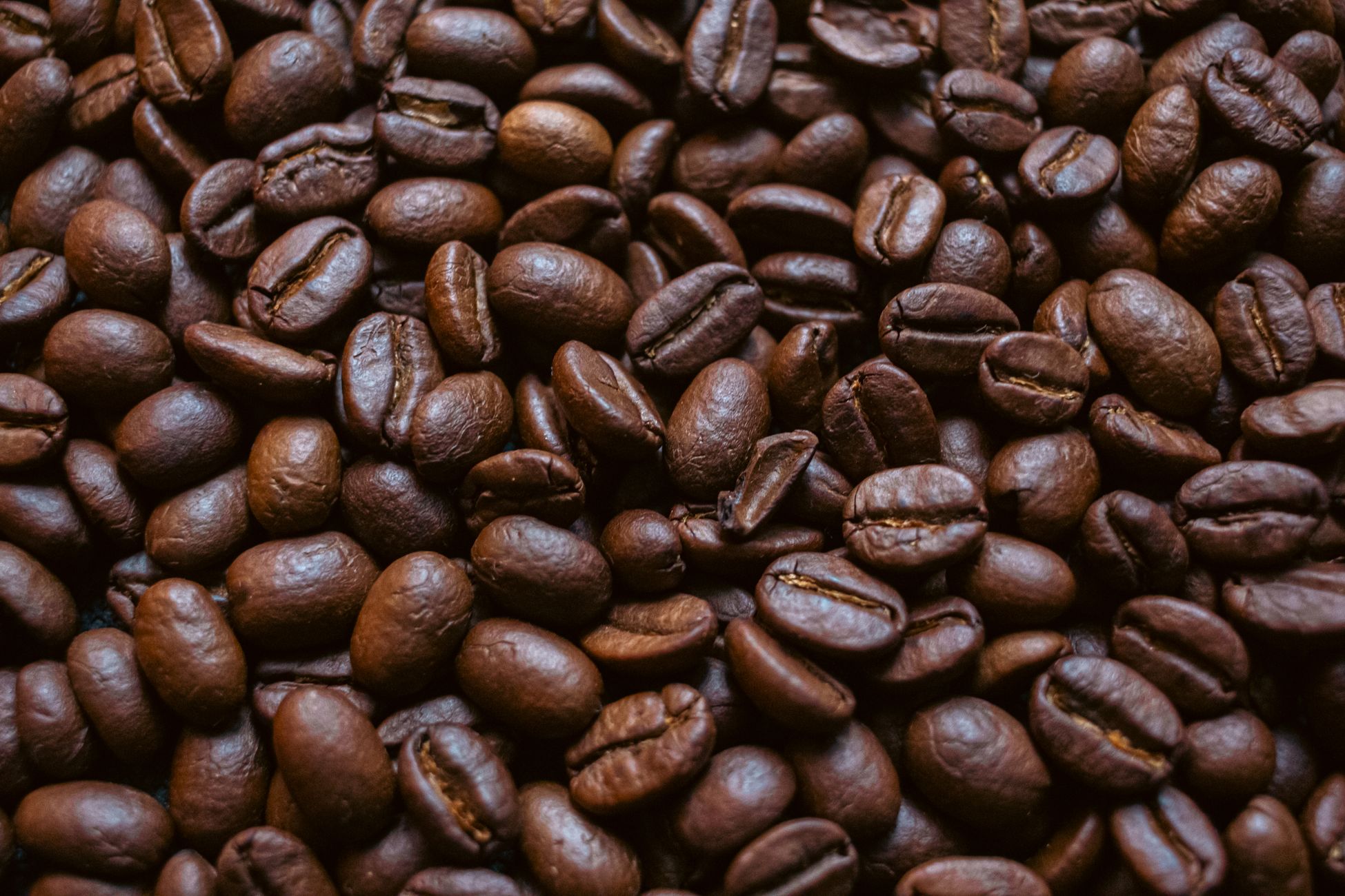 Rich brown roasted coffee beans filling the frame, perfect for coffee enthusiasts.