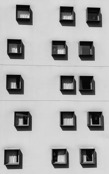 Black and white photograph of unique window design in a grid pattern on a modern building facade.