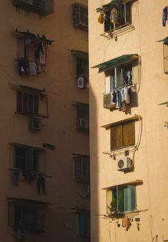 Apartment balconies with drying clothes and sunlight in Vietnam, showcasing daily urban life.