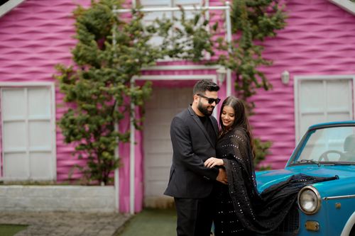 Free A couple embraces in front of a colorful house in Gurugram, India. Stock Photo