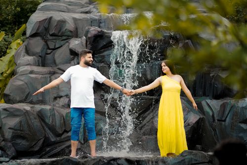 Free A couple in love holds hands in a scenic waterfall setting, Gurugram. Stock Photo