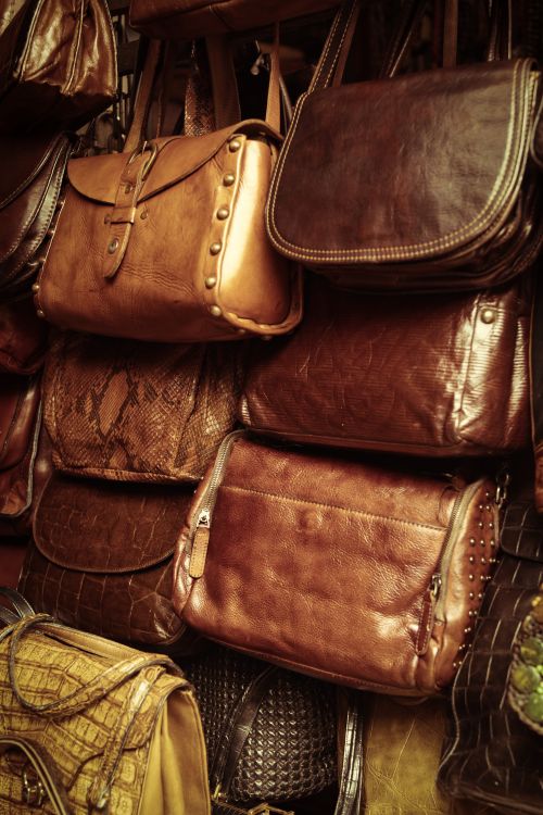 Free A collection of vintage leather bags in various styles and colors showcased in a market stall. Stock Photo
