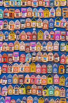 Vibrant display of Moroccan souvenirs on a blue wall in Rabat, showcasing intricate geometric designs.