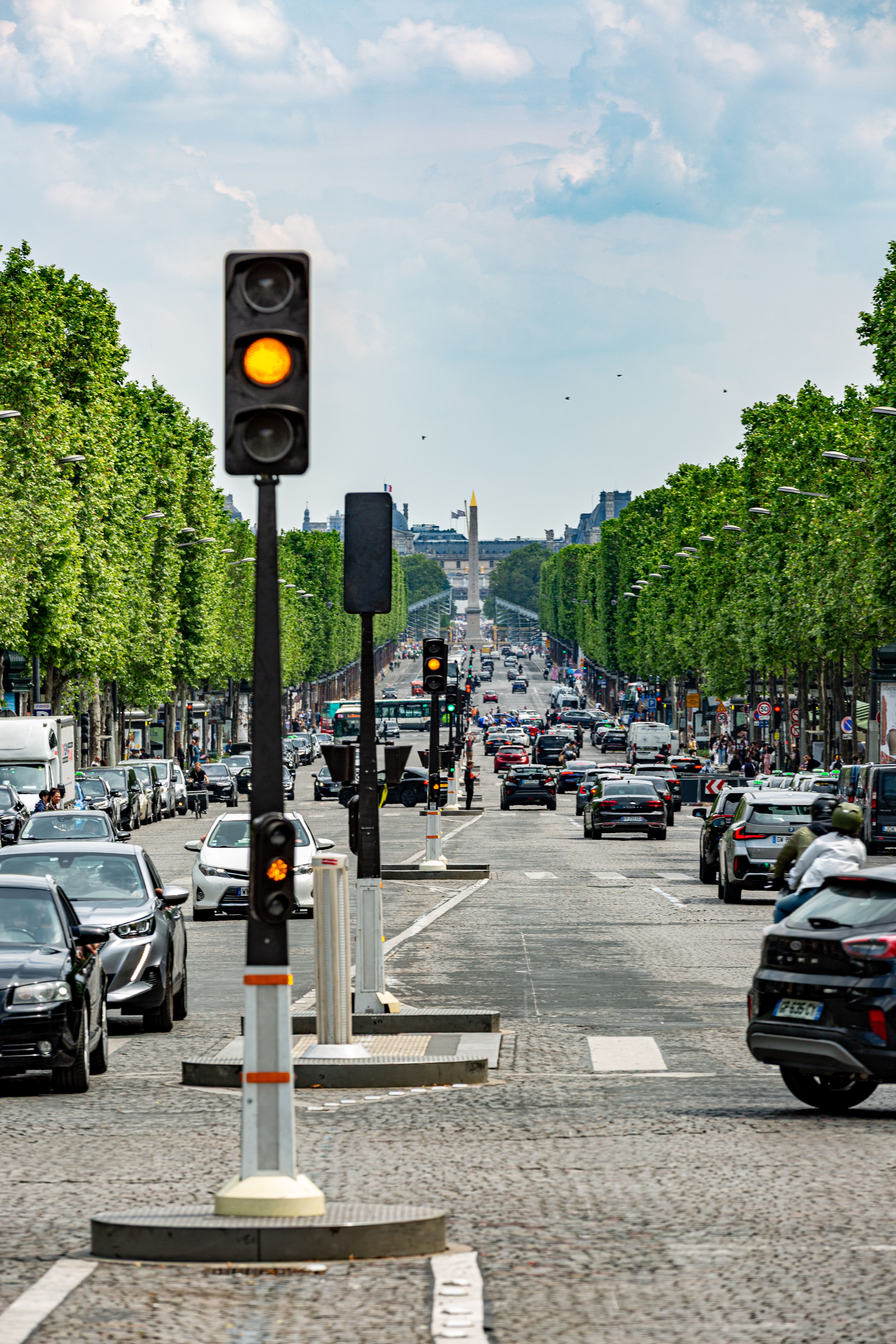 Lively traffic scene on the Champs-Élysées in Paris, featuring the iconic obelisk.