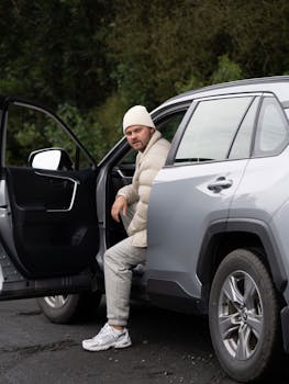 A man sitting in an open SUV door in Kaikoura, New Zealand, in a casual moment.