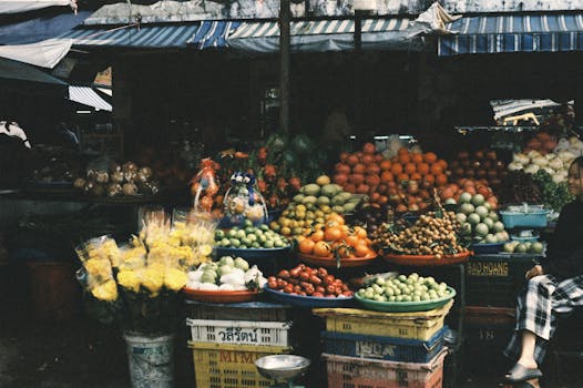 A bustling outdoor market stall displaying a variety of colorful fruits and vegetables.