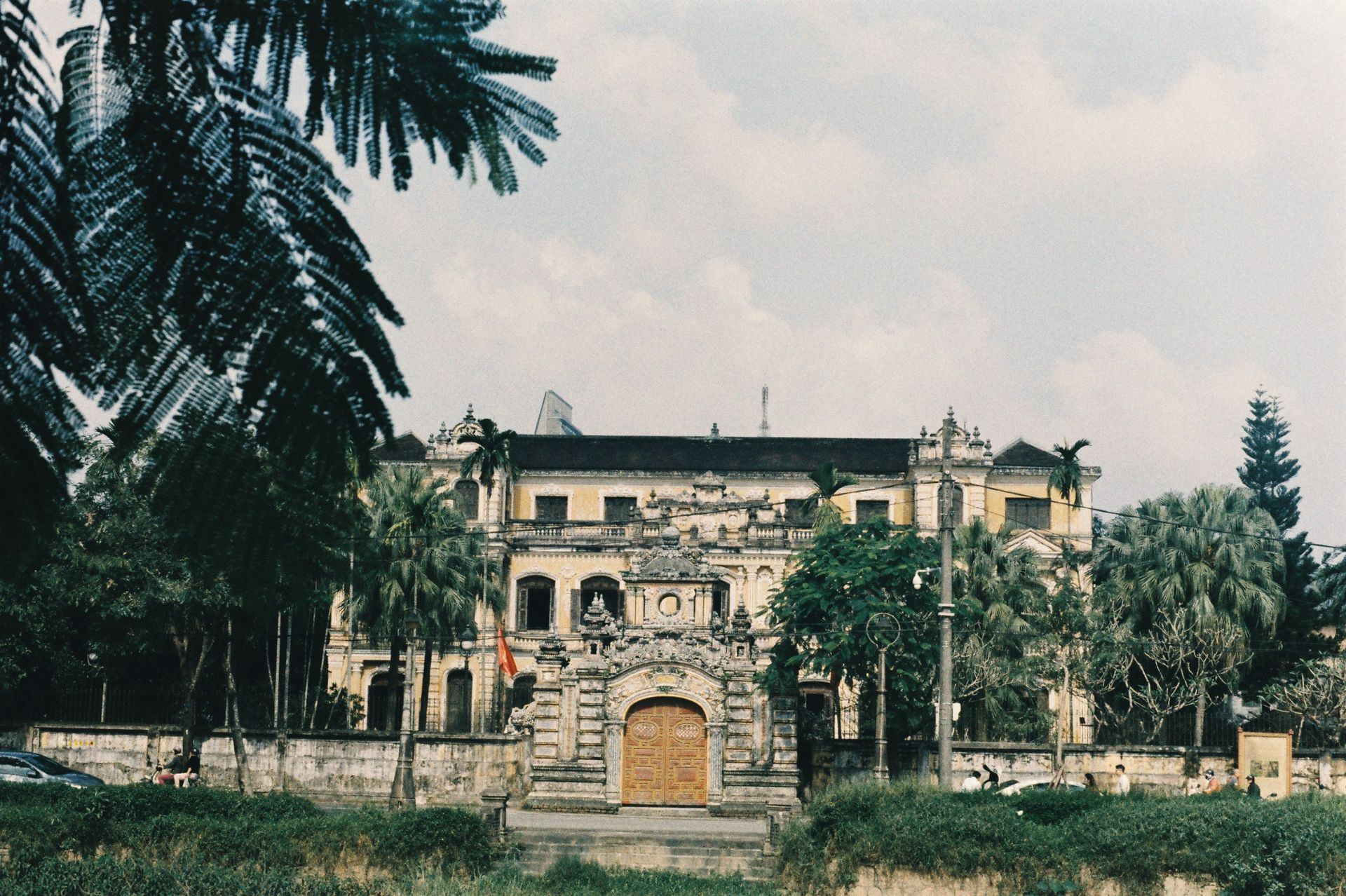 A historic colonial building captured on a sunny day, surrounded by lush palm trees.