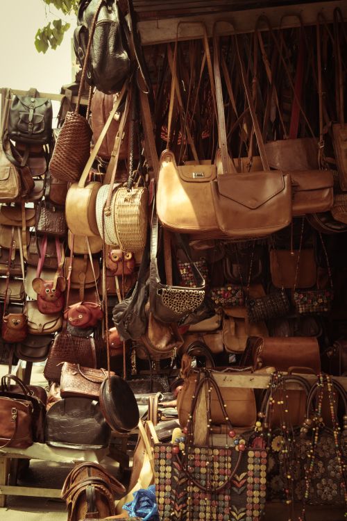 Free Assorted leather handbags displayed at an outdoor market stall, showcasing different styles. Stock Photo