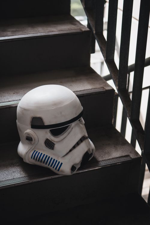 Free Stormtrooper helmet lying on a staircase, capturing a blend of sci-fi and urban decay. Stock Photo