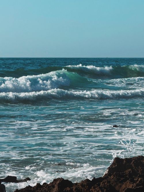 Free Dynamic waves crashing against the rocky coastline in Larache, Morocco. Stock Photo