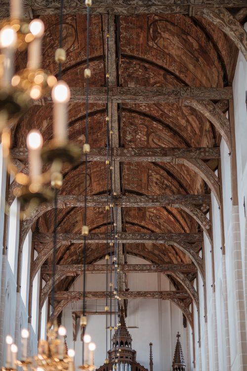 Free A stunning view of a Gothic-style vaulted ceiling featuring chandeliers in a historic church in Naarden, Netherlands. Stock Photo