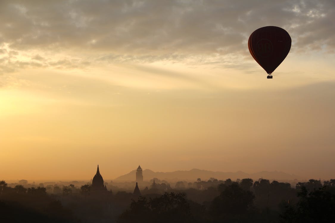 бесплатная Воздушный шар и силуэт города в дневное время Стоковое фото
