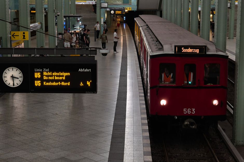 Vintage train at busy Berlin station platform with passengers boarding, highlighting urban transit.