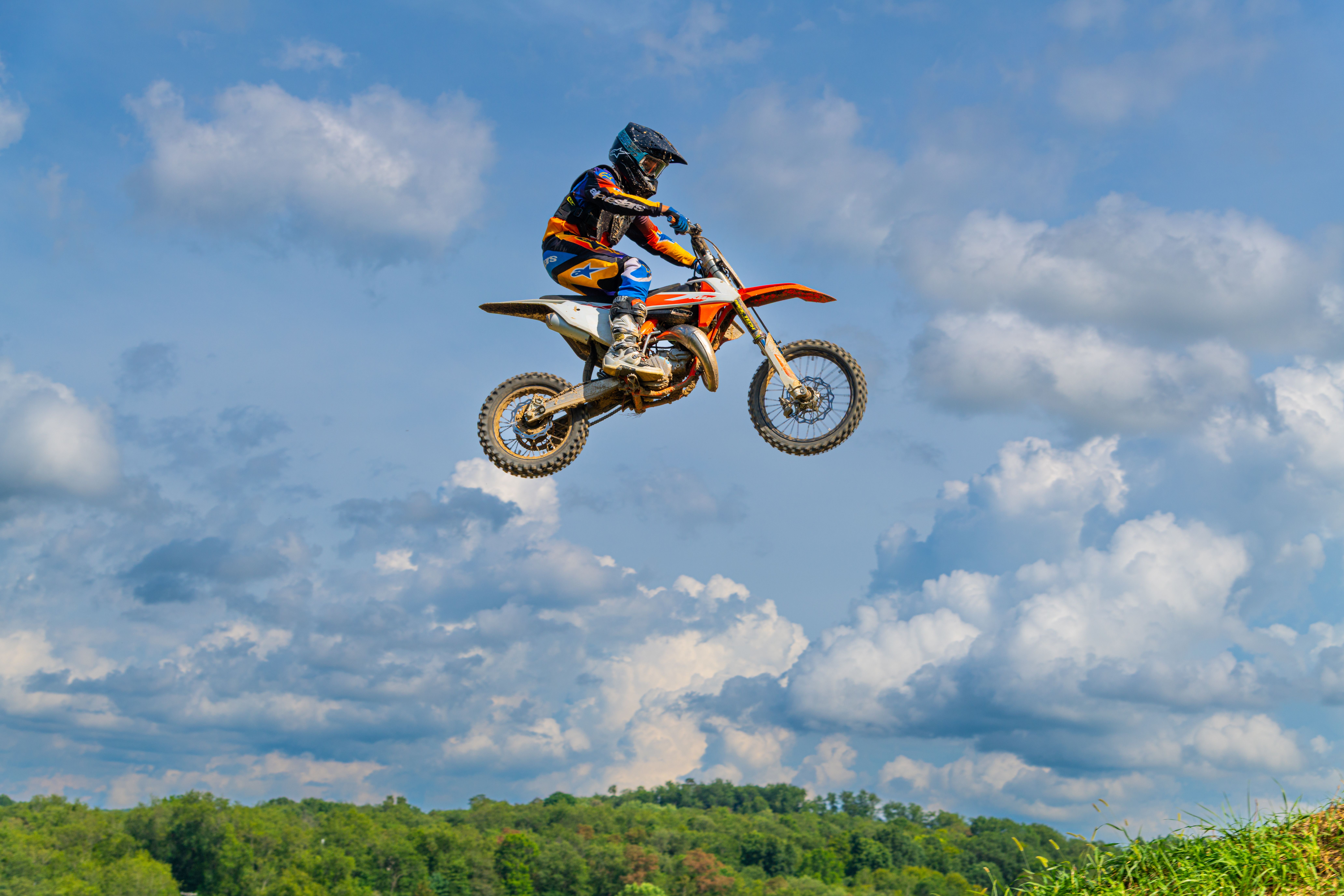 Dirt Bike Racer in Mid-Air Jump Against Blue Sky · Free Stock Photo