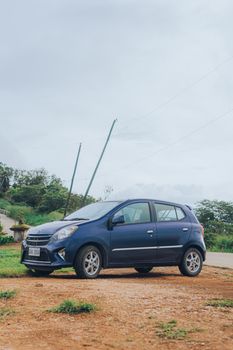 Blue hatchback parked on a dirt road, showcasing modern design elements.