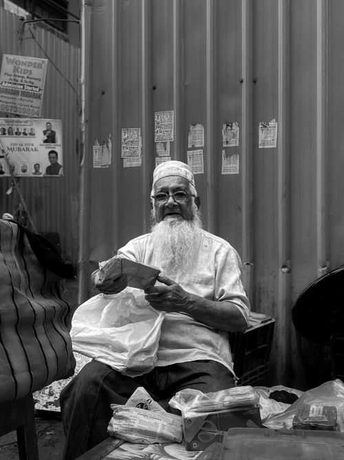 Free Portrait of an elderly vendor selling goods in a Mumbai street market. Stock Photo
