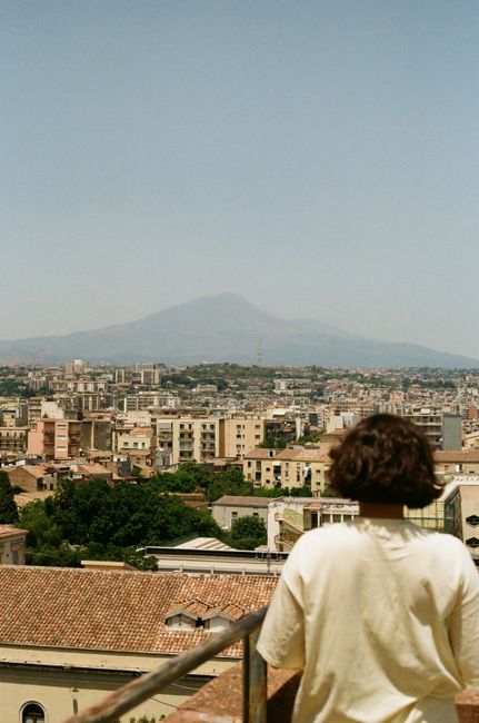 View over Catania cityscape with Mount Etna in the distance, captured from a rooftop.