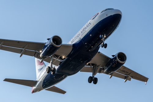 Free A British Airways Airbus A320 airplane flying over Manises, Spain under blue skies. Stock Photo