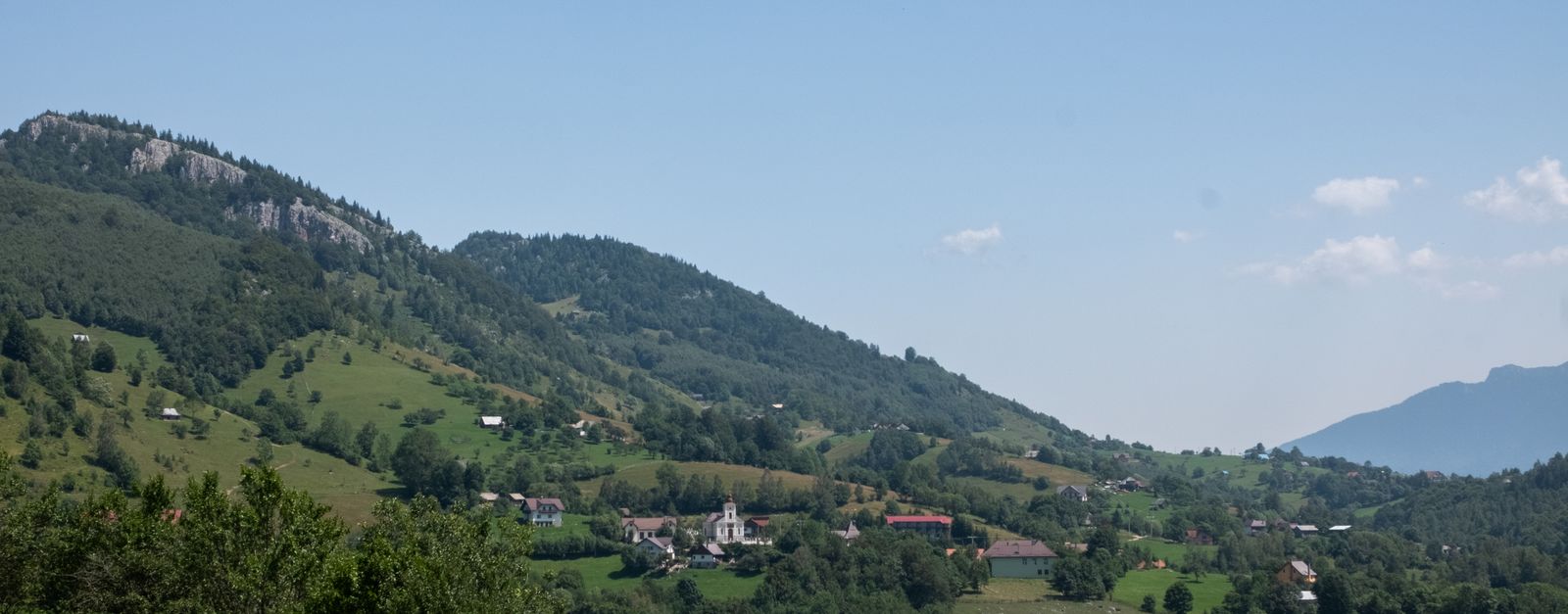 Beautiful summer view of the lush hills and village in Măgura, Brașov, Romania.