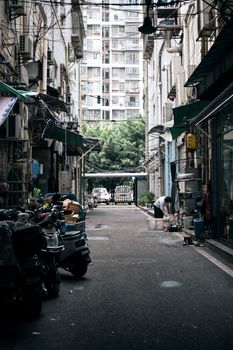 A bustling alleyway depicting daily life with shops and buildings.