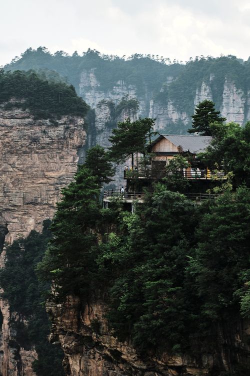 Free A serene house perched amidst lush green mountains, offering a beautiful nature escape. Stock Photo