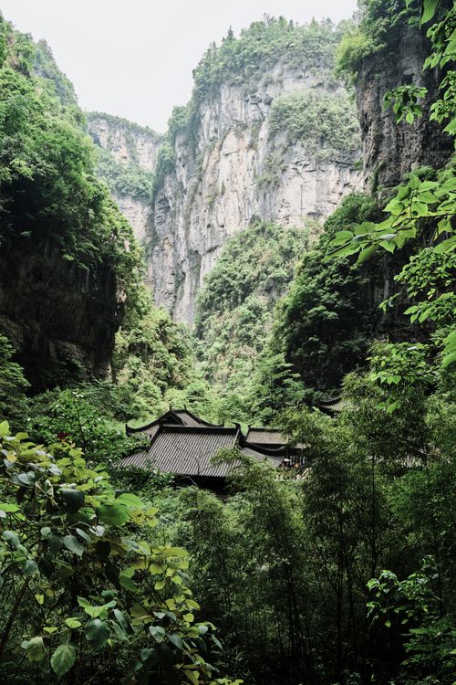 Free Tranquil temple nestled in a lush Chinese mountain valley, surrounded by greenery. Stock Photo