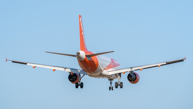 Rear view of an EasyJet Airbus A320 aircraft landing at Valencia Airport, clear sky.