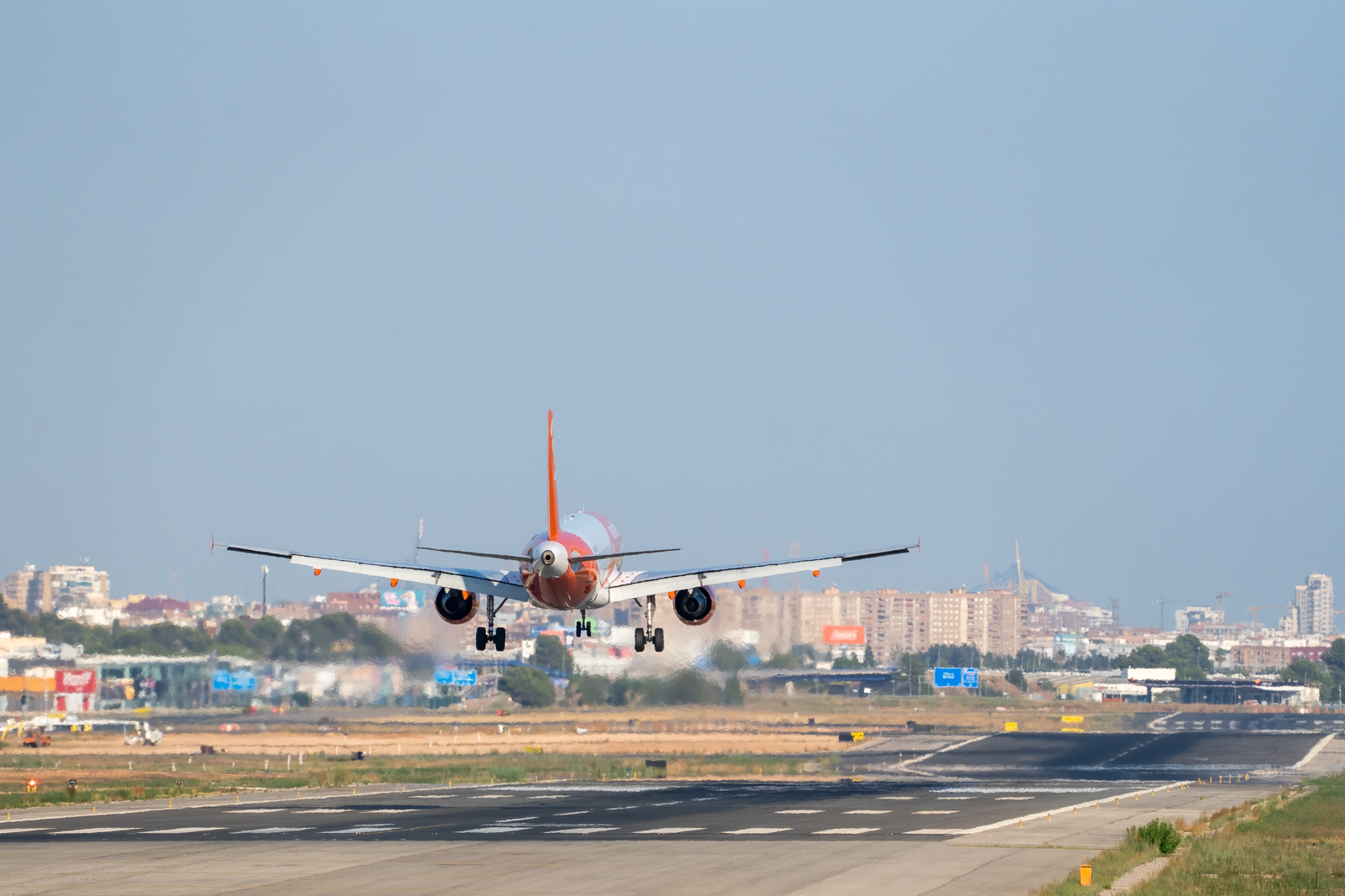 Airplane Landing at Airport Runway with Control Tower · Free Stock Photo