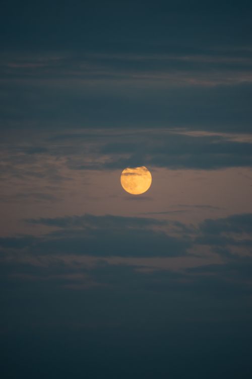 Free A tranquil full moon captured in a cloudy night sky, offering a serene and moody atmosphere. Stock Photo