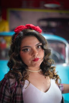 Vintage style portrait featuring a woman with a classic car in the background.
