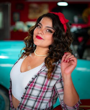 Portrait of a woman with retro hairstyle and red bandana, posing indoors with a vintage flair.