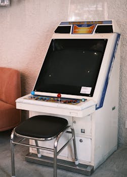 A classic arcade machine with a vibrant control panel in a retro indoor space.