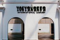 Front view of Yogyakarta International Airport entrance with shadow play on white facade.