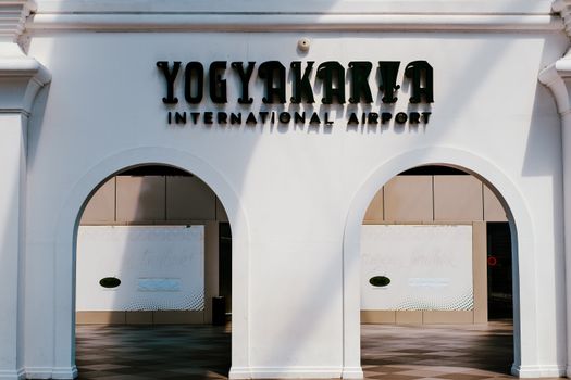 Front view of Yogyakarta International Airport entrance with shadow play on white facade.