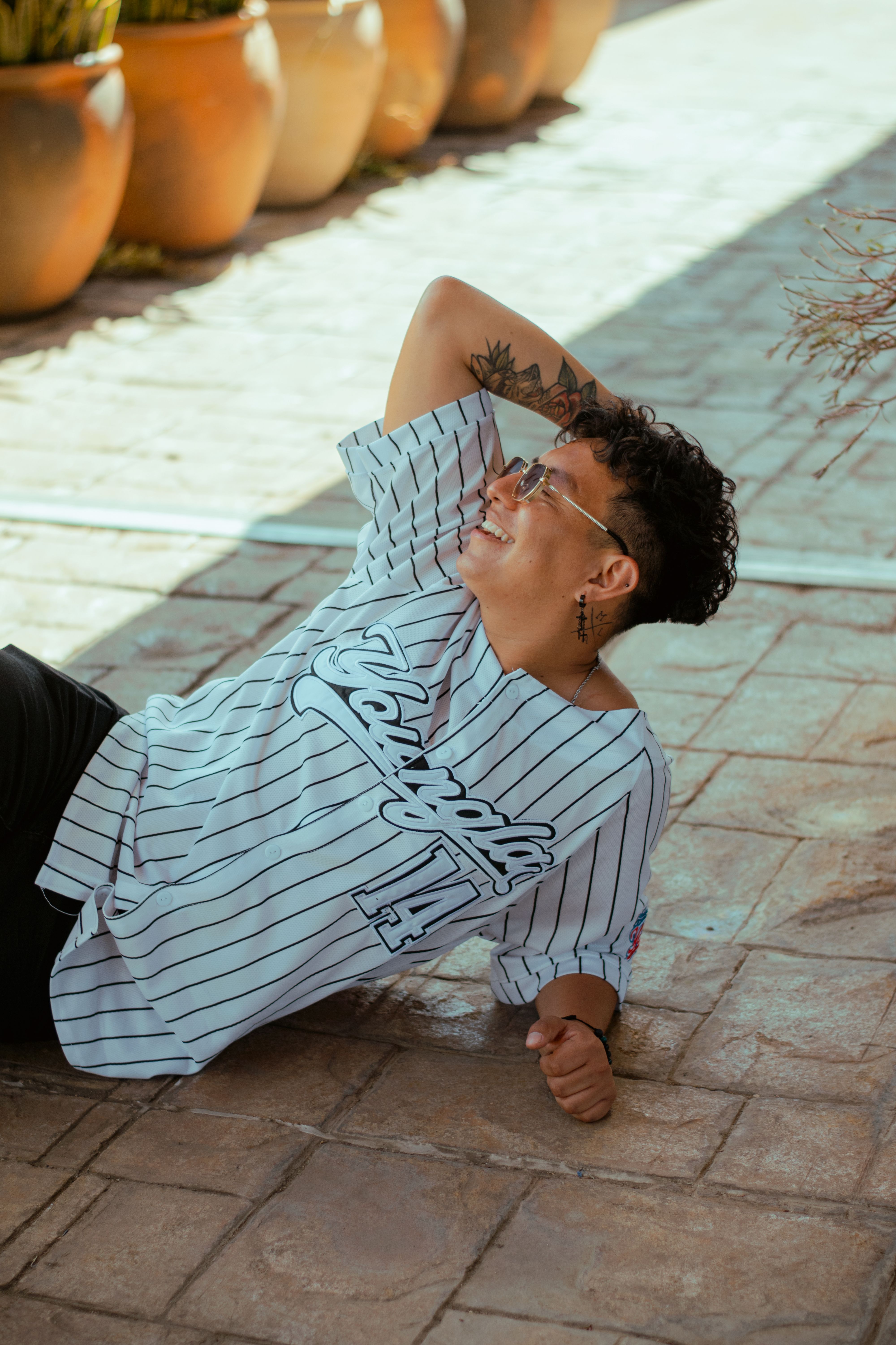 A stylish person with tattoos and sunglasses enjoying a sunny day in Oaxaca, Mexico.