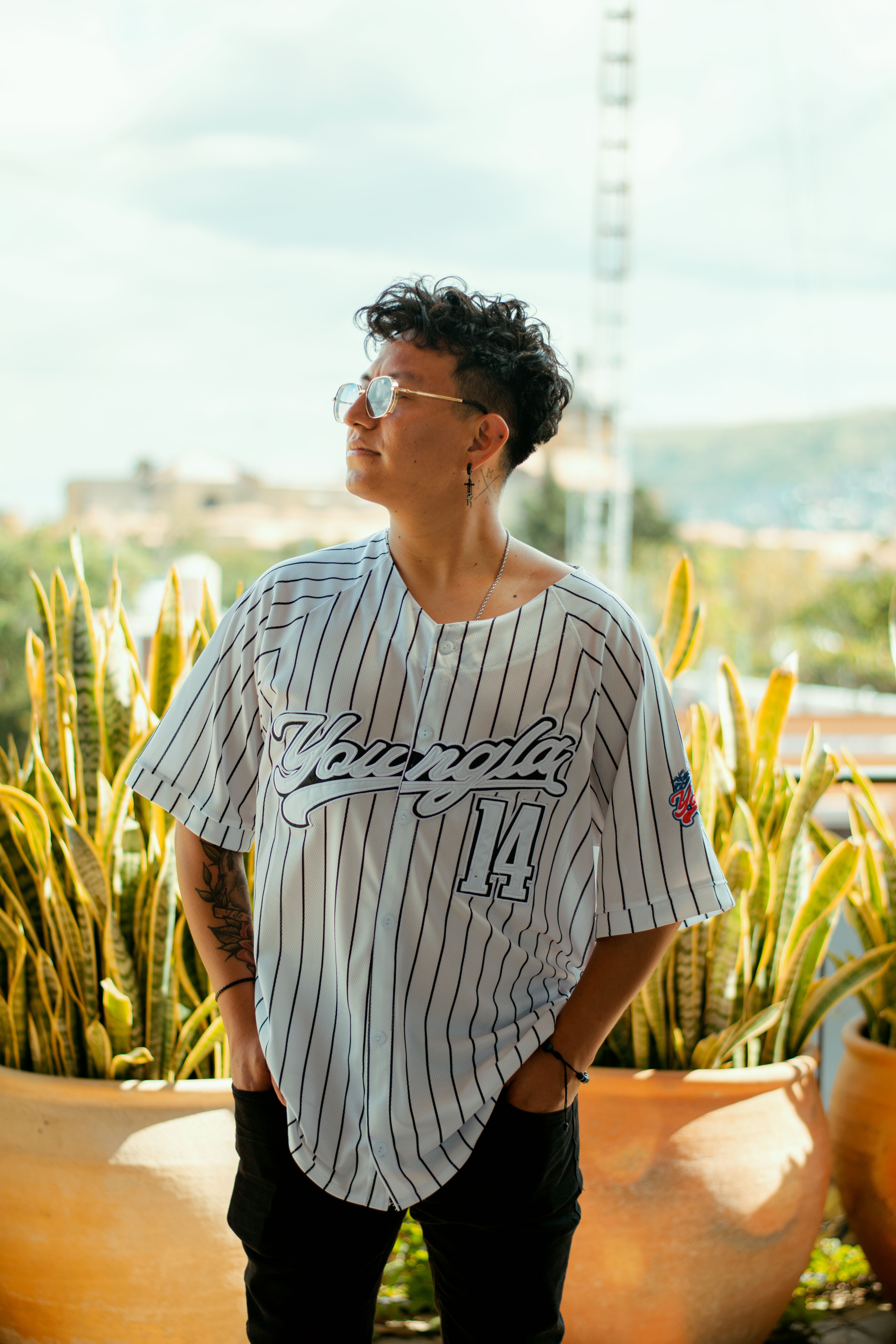 A fashionable individual in a striped shirt outdoors in Oaxaca, Mexico, exuding confidence and style.