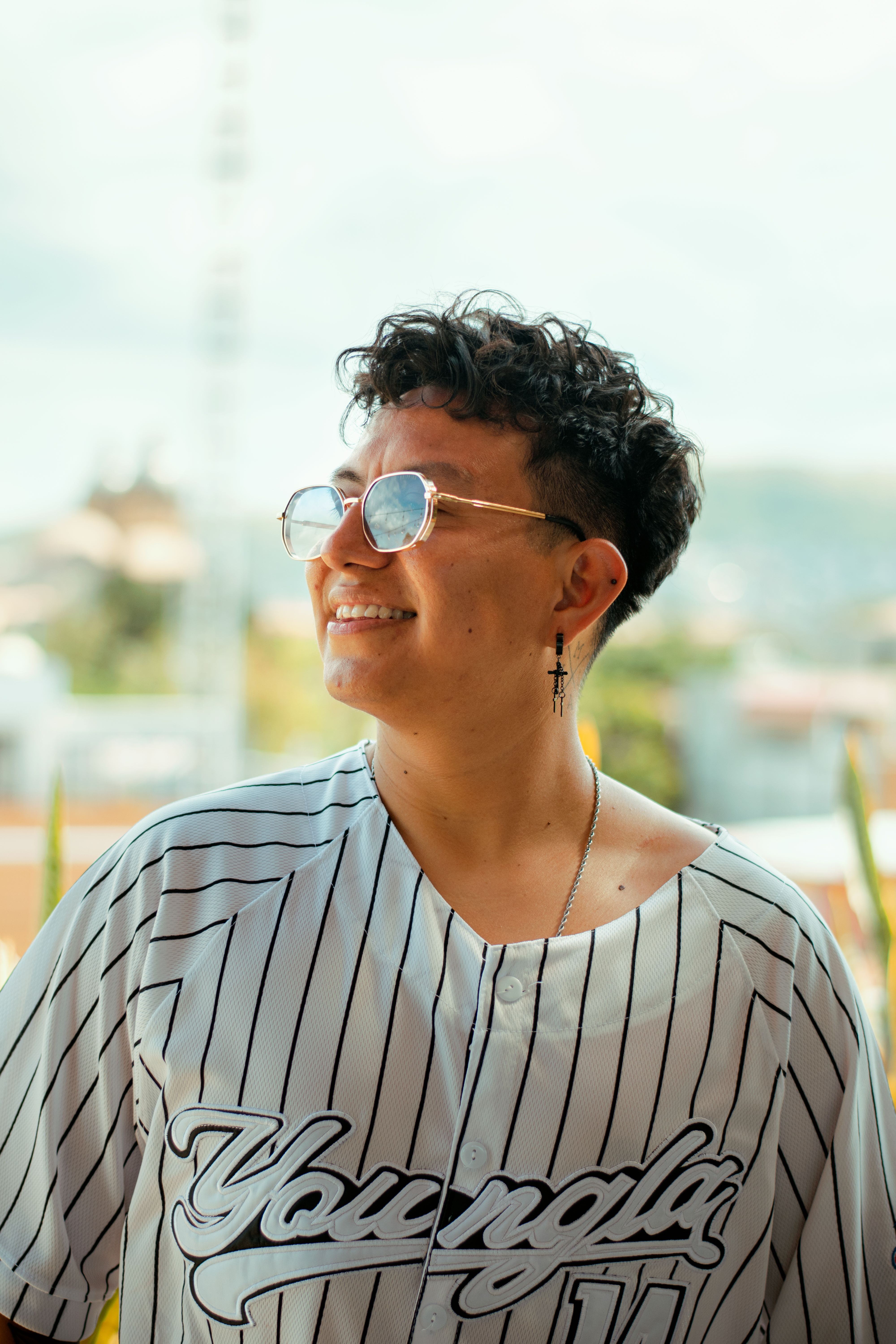 Portrait of a stylish young adult wearing sunglasses in sunny Oaxaca, Mexico.