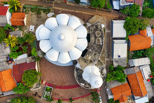 Drone shot showcasing a distinctive dome structure surrounded by rural roofs in South Tangerang, Indonesia.