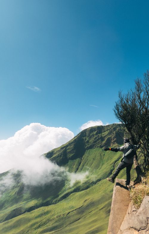 Free An adventurer standing on a cliff at Mount Prau in Java, Indonesia. Stock Photo