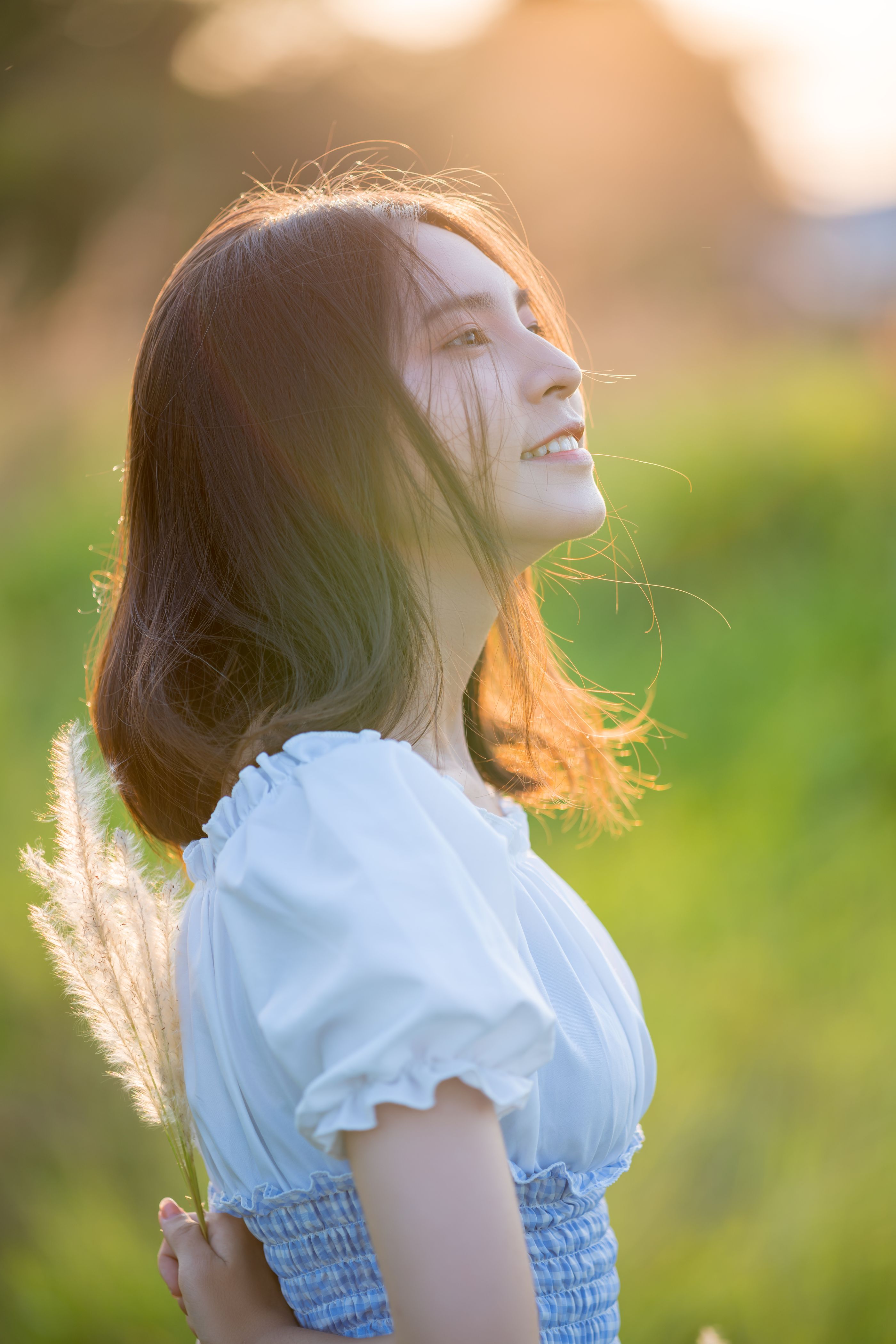 Serene woman outdoors at golden hour in a soft warm field of light