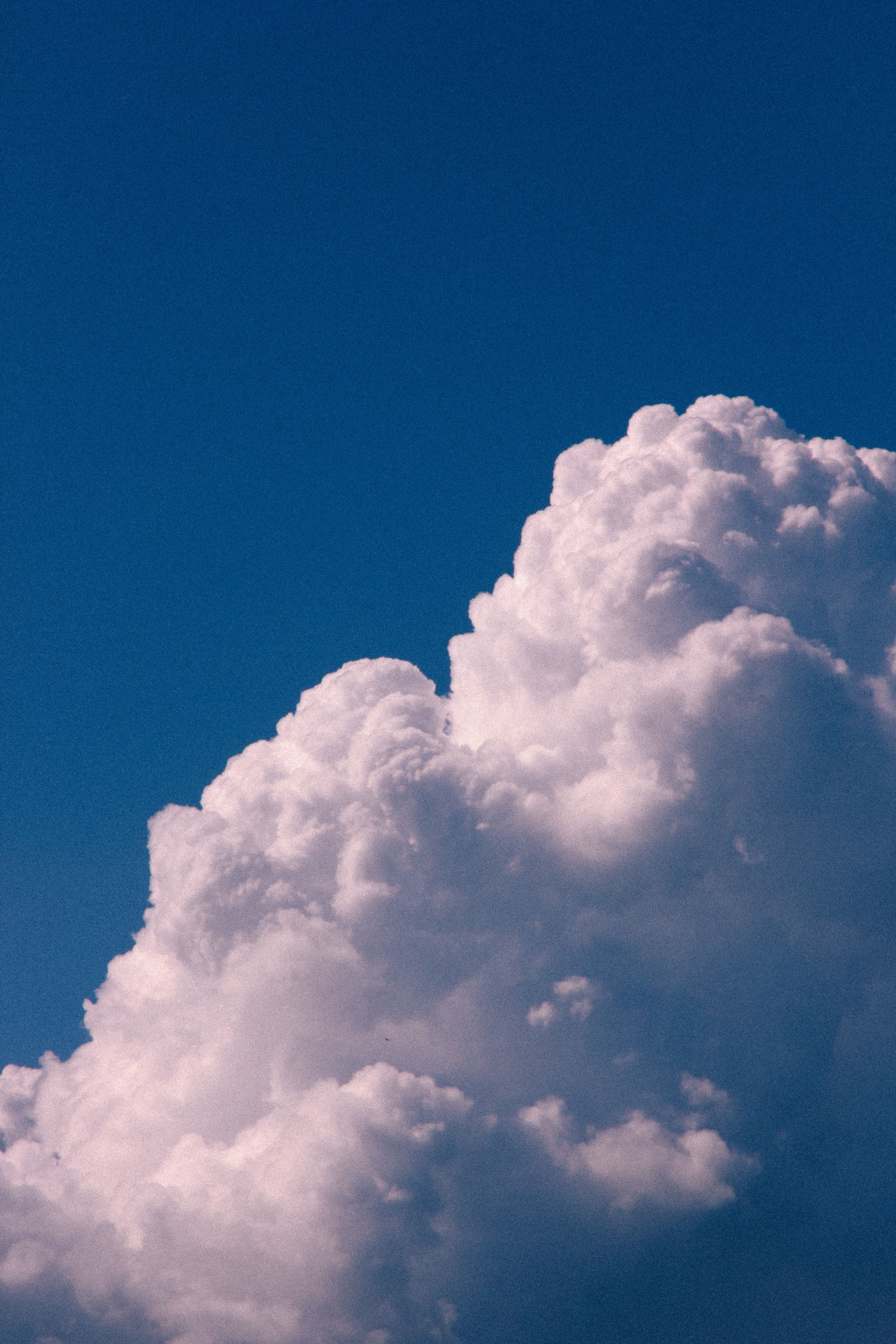 A stunning view of a large cumulus cloud under a clear blue sky, capturing the essence of nature's beauty.