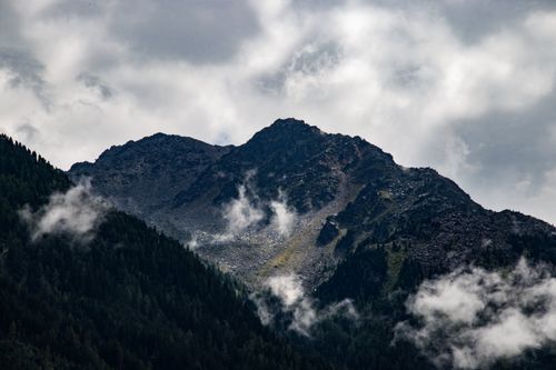 Free Breathtaking view of a rugged mountain peak shrouded in dramatic clouds. Stock Photo