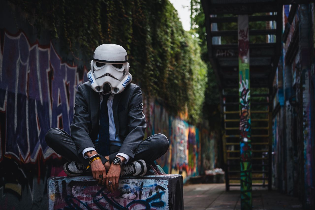 man in stormtrooper helmet sitting in graffiti covered alley g tersloh