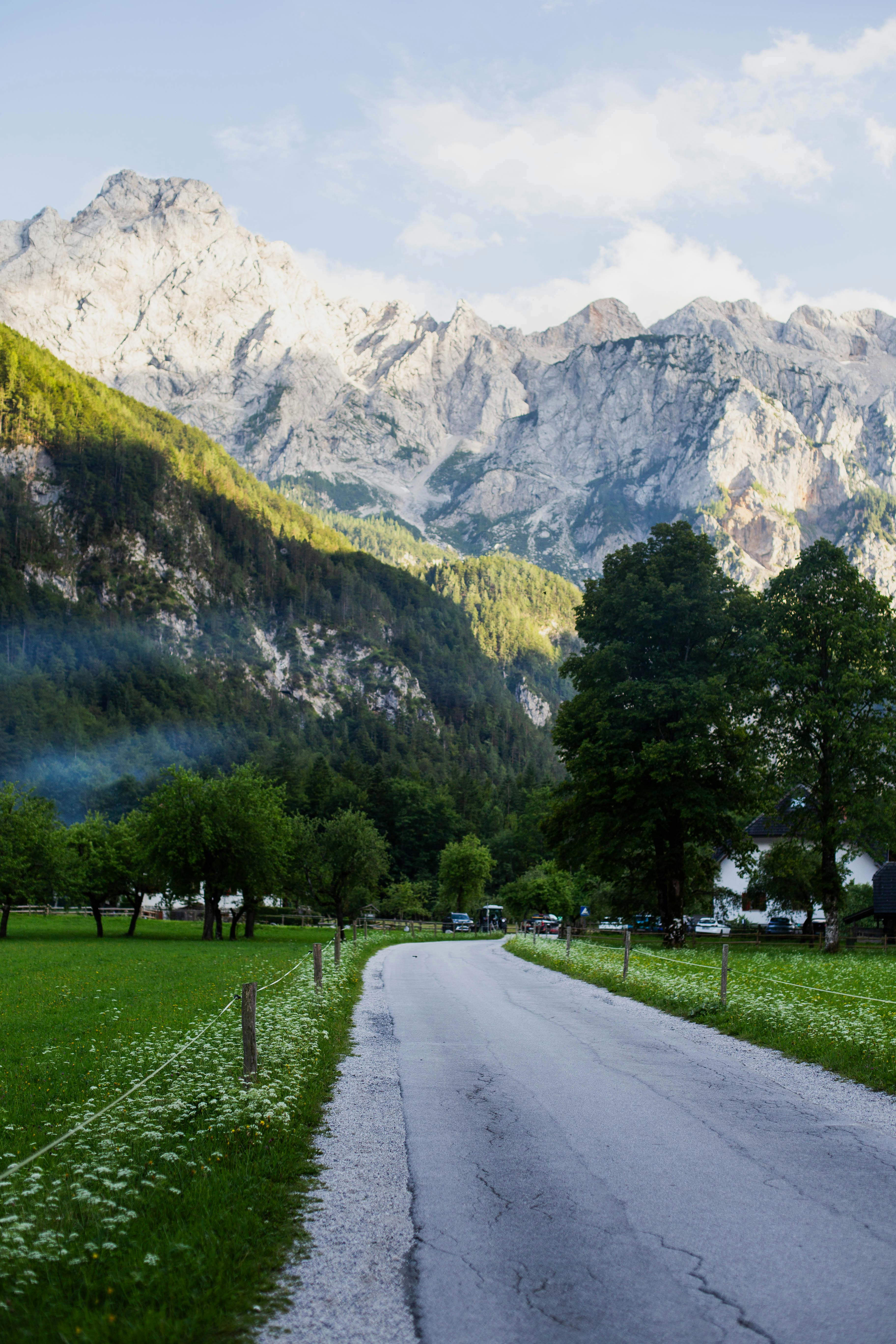 Scenic rural road leading towards majestic mountains in Slovenia