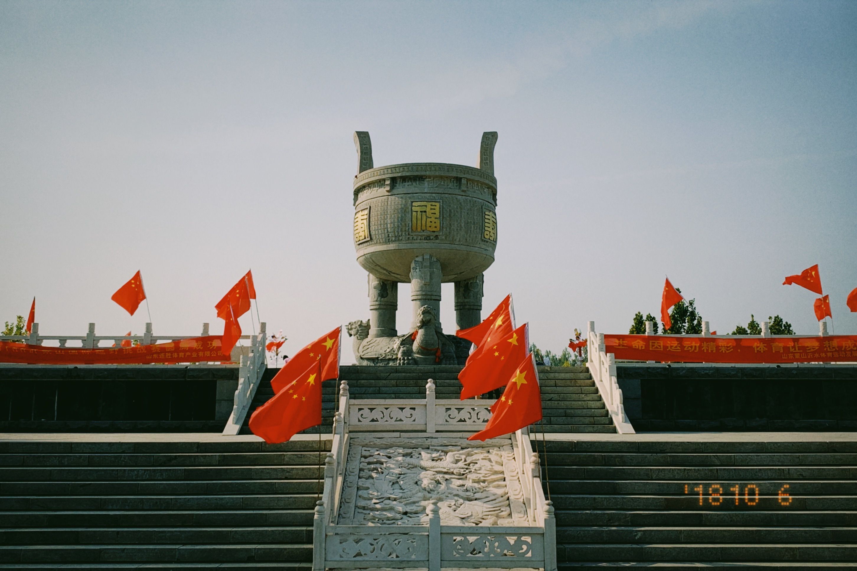 晴れた空の下で国旗が飾られた古代中国の記念碑。