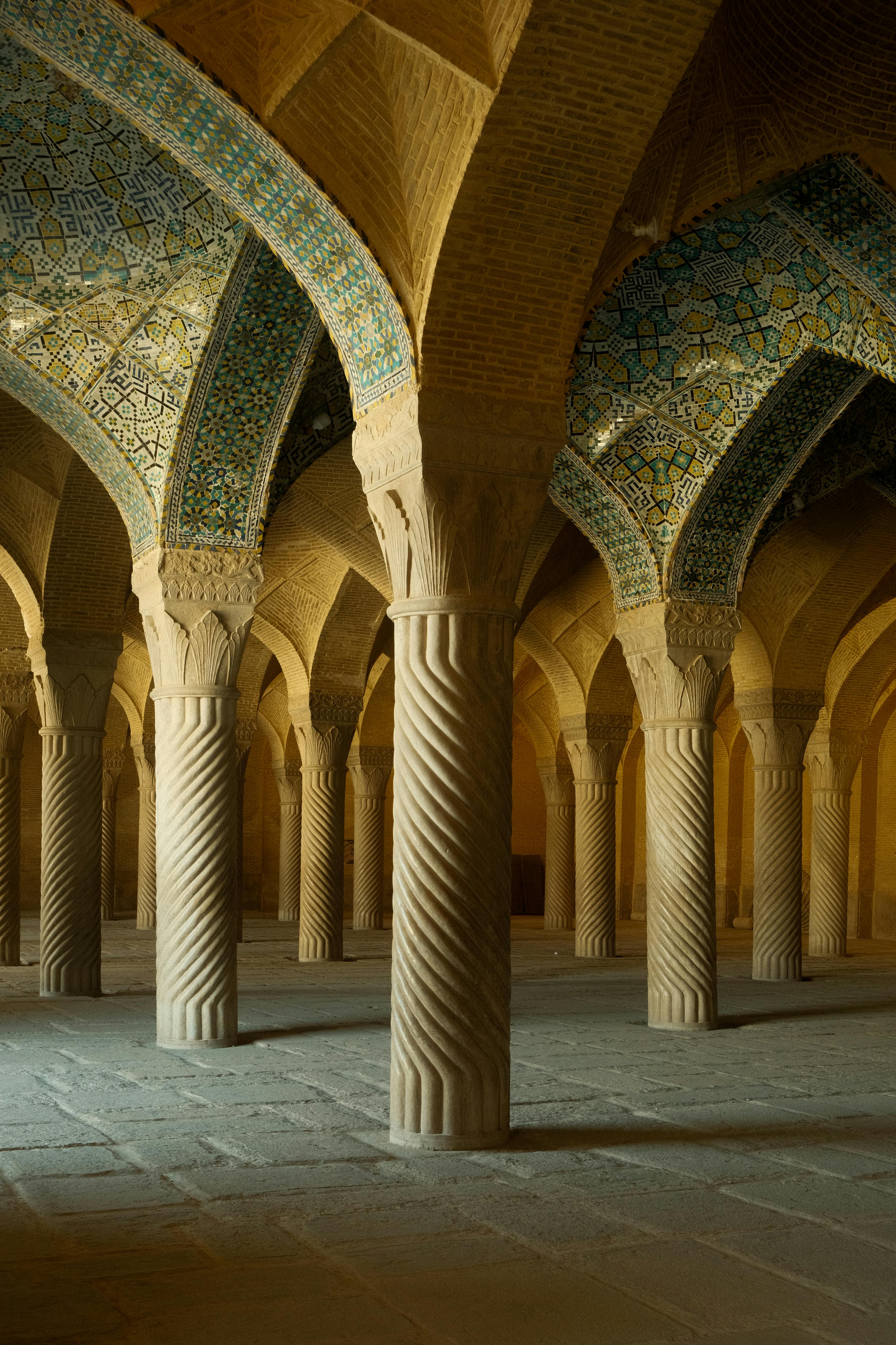 Intricate columns of the Vakil Mosque in Shiraz, showcasing Persian architectural beauty.