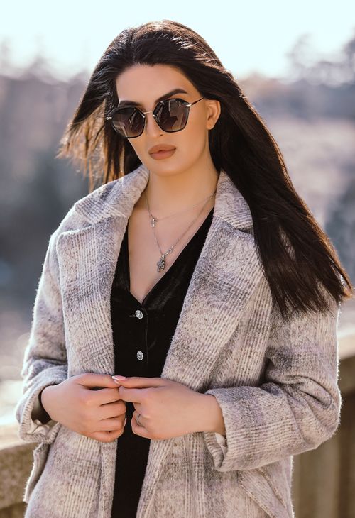Free A fashionable woman in sunglasses and a coat stands confidently outdoors, showcasing elegance and style. Stock Photo